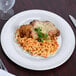 A Carlisle white melamine plate with cheese and pasta.