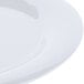 A close up of a Carlisle white melamine plate with a wide rim.