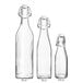 Three Acopa clear glass bottles with wire bail swing top lids.