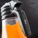 A Tablecraft polypropylene blank dispenser tag on a plastic bottle on a counter.
