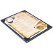 A Menu Solutions wood menu board with picture corners on a table.