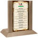 A Menu Solutions weathered walnut wood menu holder on a table with a menu in it.