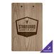 A weathered walnut wood menu clip board on a table with a logo.