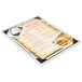 A Menu Solutions white wash wood menu board with picture corners on a white table with a menu displayed.
