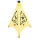 A yellow Rubbermaid "Caution" wet floor cone with black text.