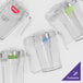 A group of clear Cambro stackable pitchers with different colored labels.