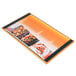 A Menu Solutions customizable wood menu board with top and bottom strips on a table with a plate of food with shrimp.