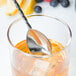 A Barfly stainless steel bar spoon in a glass of liquid.