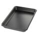 A black Chicago Metallic BAKALON aluminum sheet pan with a curled rim on a counter.