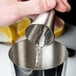 A person using a Barfly stainless steel Japanese style jigger to pour liquid.