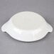 A Hall China bright white au gratin dish on a gray surface.