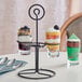 An Acopa metal stand holding three pub tasting glasses filled with dessert.