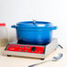 A cobalt blue oval Dutch oven with a lid on a counter.