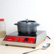 A GET Heiss gray enamel coated cast aluminum dutch oven with lid on a stove.