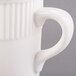 An 8 oz. ivory embossed rim china mug with a handle.