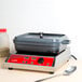 A gray enamel coated cast aluminum roasting pan with a lid on a counter.