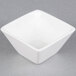 An American Metalcraft white square porcelain sauce cup on a gray surface.