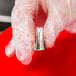 A hand in a glove using an Ateco 3-hole metal piping tip.