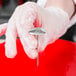 A person holding a Ateco stainless steel flower nail.