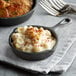 A Valor pre-seasoned cast iron skillet filled with macaroni and cheese on a table with a fork.