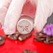 A person in gloves using an Ateco Russian piping tip to decorate a metal container.