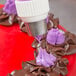 A person using an Ateco Russian piping tip to decorate a cake.