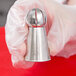 A person holding a stainless steel Ateco Russian ball tip.