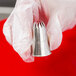 A hand holding an Ateco closed star piping tip.