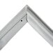 A close-up of a white metal corner piece of a drawer gasket.