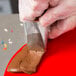 A person using an Ateco rose piping tip to decorate a cake.