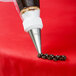A person using an Ateco open star piping tip to pipe chocolate onto a pastry.