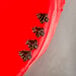 A red cake with chocolate Christmas trees piped on it using an Ateco Christmas Tree piping tip.