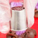 A person holding an Ateco Russian piping tip with chocolate on it.