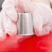 A person in gloves using an Ateco Russian piping tip to decorate a pastry.