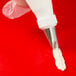 A pastry bag with a white frosting tip.