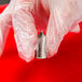 A person holding a silver metal Ateco leaf piping tip.