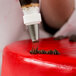 A person using an Ateco grass piping tip to decorate a cake with a pastry bag.