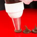 A pastry bag with Ateco drop flower piping tip making chocolate frosting.