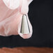 A hand holding an Ateco closed star piping tip.