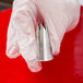 A hand holding a silver Ateco Swirl Top Piping Tip.