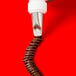 A brown Ateco piping tip with a white notched ruffle tip on a brown liquid-filled piping bag.