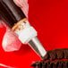 A hand using an Ateco ruffle piping tip in a pastry bag.