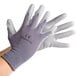 A pair of Cordova gray nylon gloves with gray polyurethane palm coating on a hand.