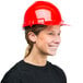 A woman wearing a red Cordova hard hat.