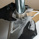 A person wearing Cordova black nylon gloves with gray palms fixing a metal pipe.