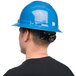 A man wearing a Cordova blue full-brim hard hat.