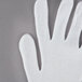 A Cordova white inspection glove on a gray surface.