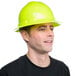 A man wearing a green hard hat with a ratchet suspension.