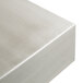 A Tablecraft stainless steel rectangular bowl with straight sides on a metal surface.