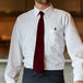 A man wearing a Henry Segal burgundy tie and a white shirt.